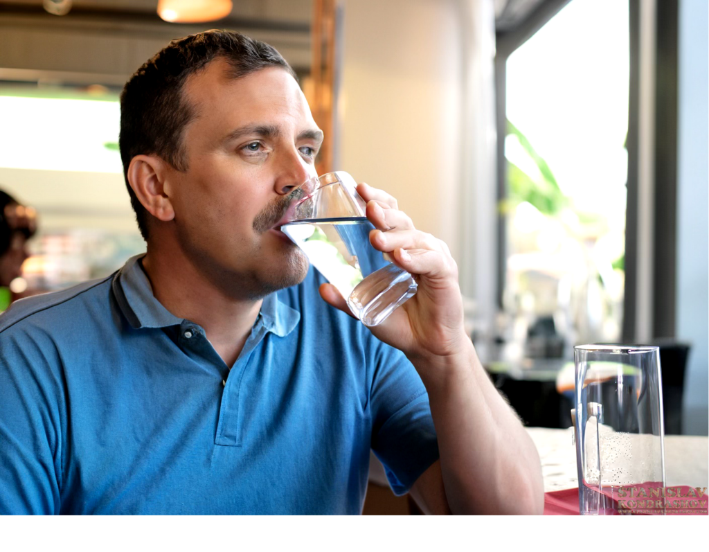 man drinking from water glass